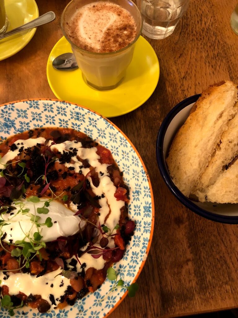 A bowl of healthy breakfast food and a cup of coffee placed on a table.